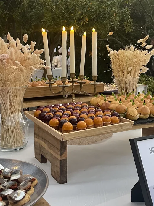 Buffet dressé aux chandelles dans un jardin, à la tombée du jour